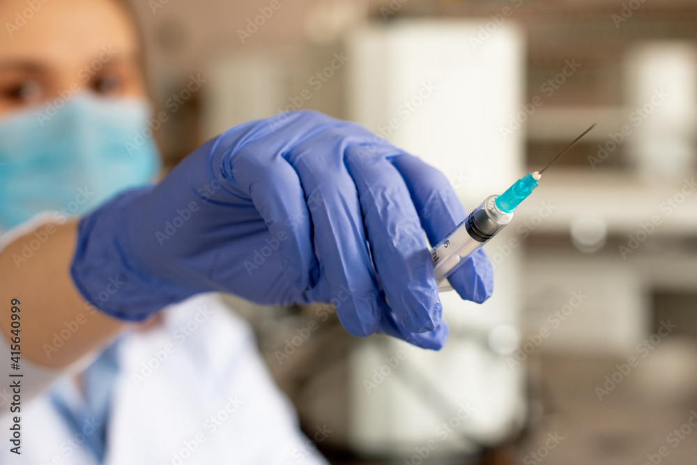 The doctor holds a syringe in blue gloves before vaccination or injection. Coronavirus concept The doctor holds a syringe in blue gloves before vaccination or injection. Coronavirus concept