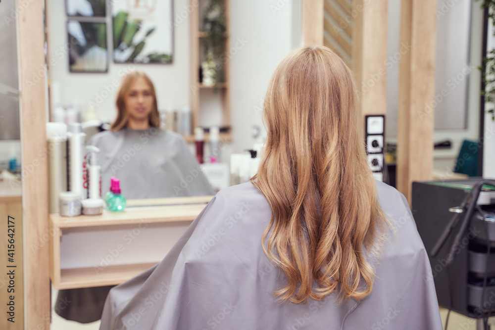 Long hair woman. Hairdresser treatment. Repair procedure. Sit at salon. Bride hairstyle. Curly styling. Adult female person. Prom lady preparation. Blonde dry. Copyspace Long hair woman. Hairdresser treatment. Repair procedure. Sit at salon. Bride hairstyle. Curly styling. Adult female person. Prom lady preparation. Blonde dry. Copyspace