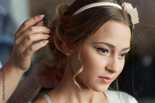 Hairdresser working on bridal knot of hair.