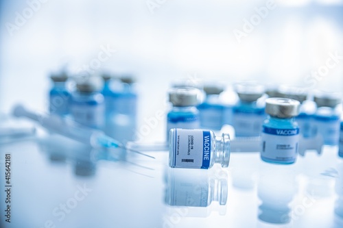 Ampoules with Covid-19 vaccine. Syringe with needle. Fighting the covid-19 virus. photo