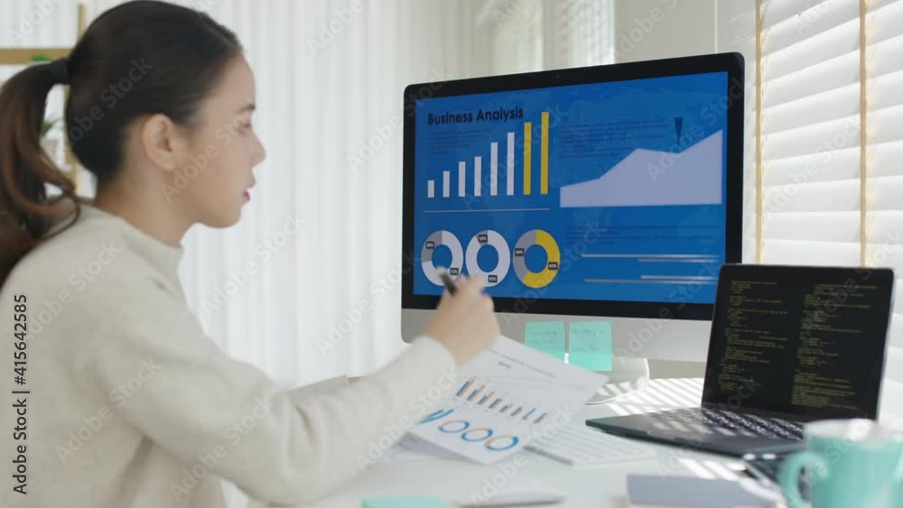 Young attractive asian thai woman employee busy work online multiple screen laptop computer or smart tablet at home in freelance sale data analytic, data science scientist engineer for business.