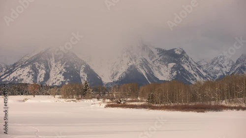 Morning timelapes of Jackson Lake in Grand Teton National Park during a cold winter morning with snow covering Jackson Lake.  photo