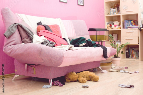 Room of a teenage girl with scattered clothes and things. The concept of a mess, general cleaning.