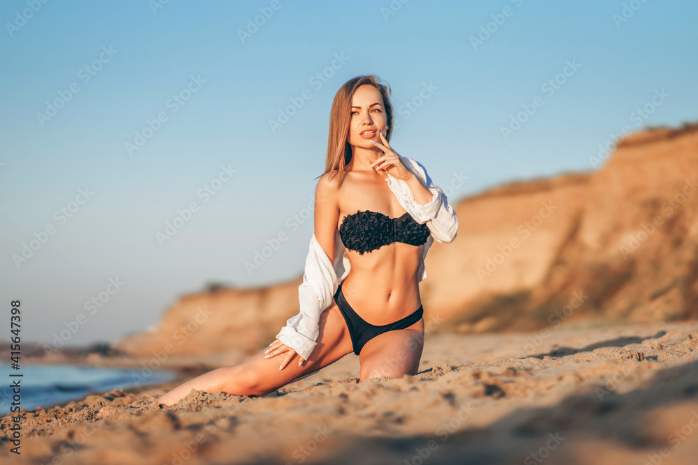 Pretty brunette woman relaxing on the beach at the sea.
