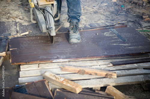 A worker cuts the wood with a petrol saw