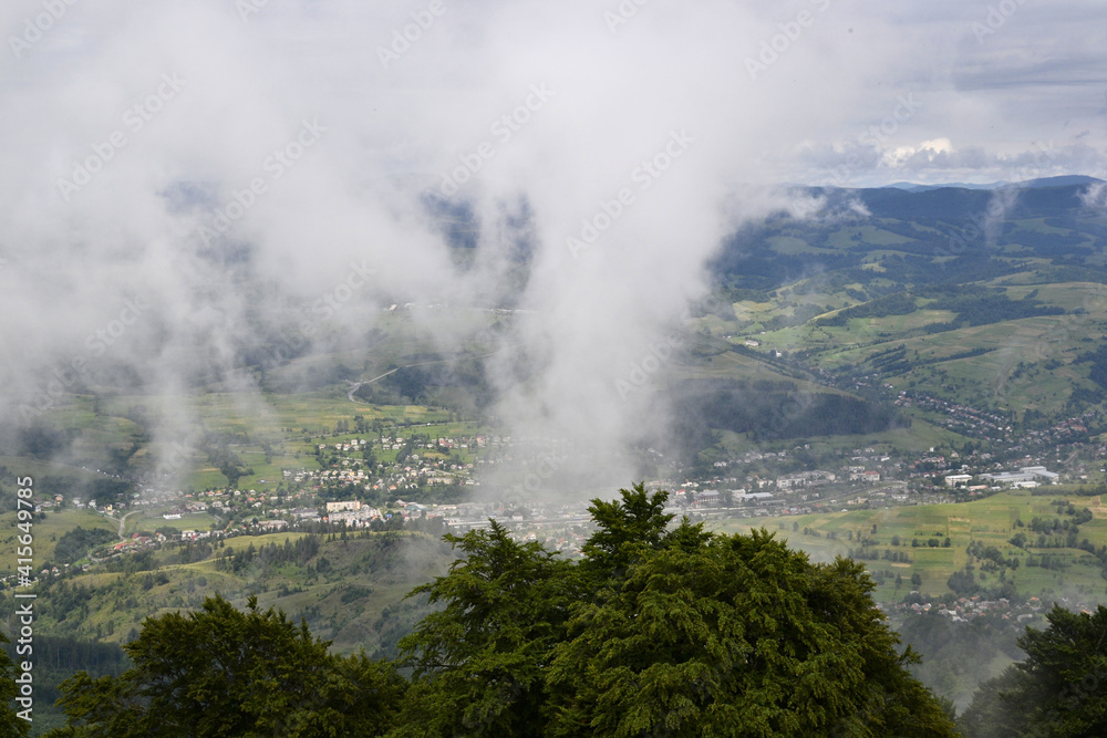 Clouds over village in the valley. Wide angle horizon view, Carpathian mountains, Ukraine