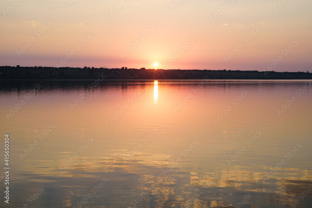 Summer landscape with reflection of colorful sunset in the lake