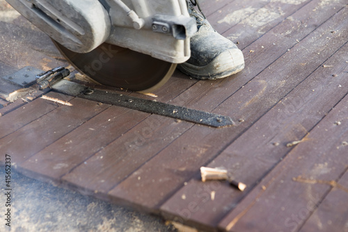 A worker cuts the wood with a petrol saw