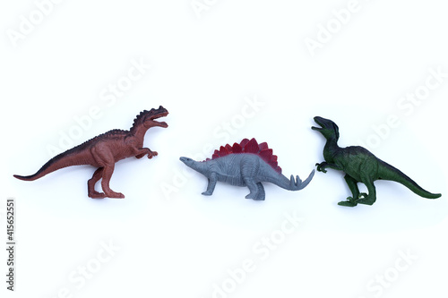 Plastic dinosaur toys on white background. Top view © Bowonpat