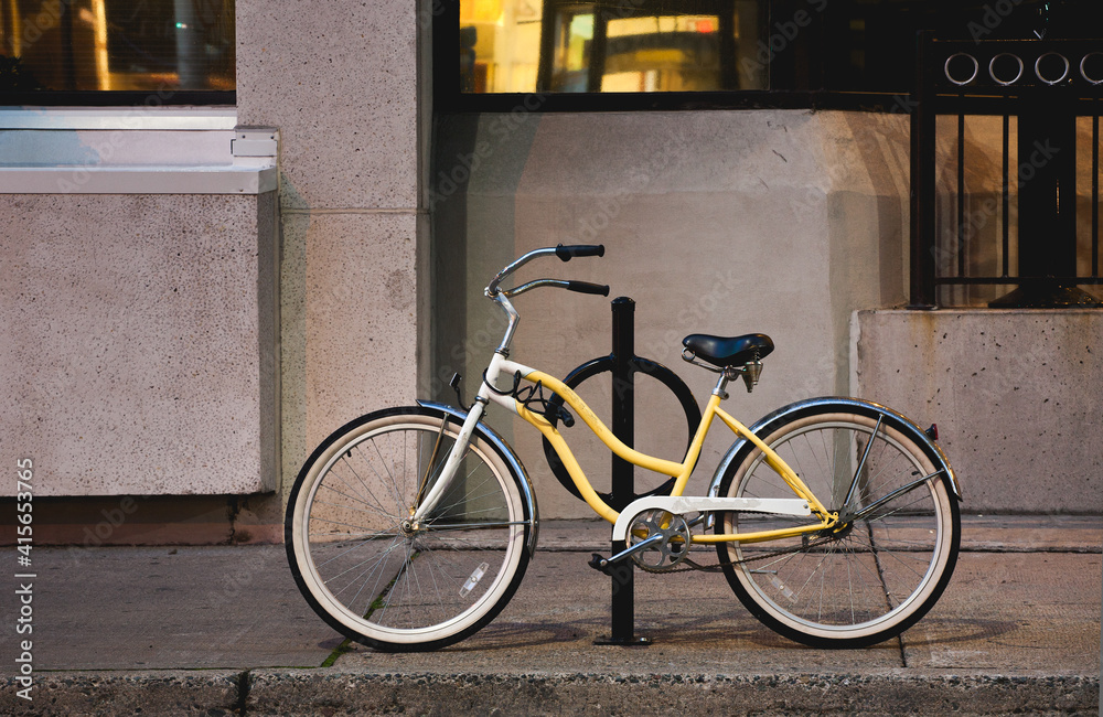 Yellow bicycle parked on city street at night Yellow bicycle parked on city street at night