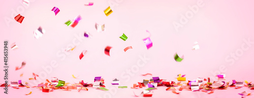 colorful confetti on a pink background. festive background