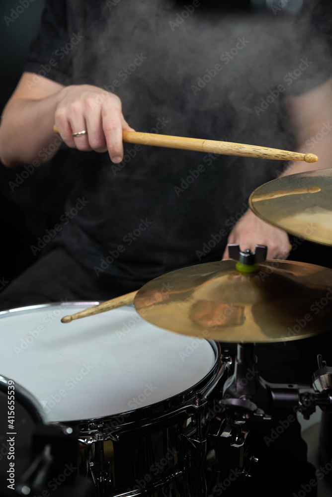 Obraz premium Professional drum set closeup. Man drummer with drumsticks playing drums and cymbals, on the live music rock concert or in recording studio 