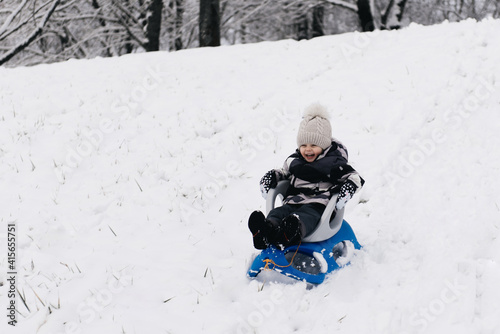 Cute cute boy in a sled in the snow, active lifestyle, winter, family