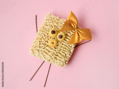creative funny instant noodles with bow on pink background.