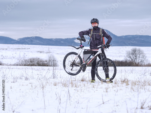 Athlete and middle-aged cyclist during winter training in land