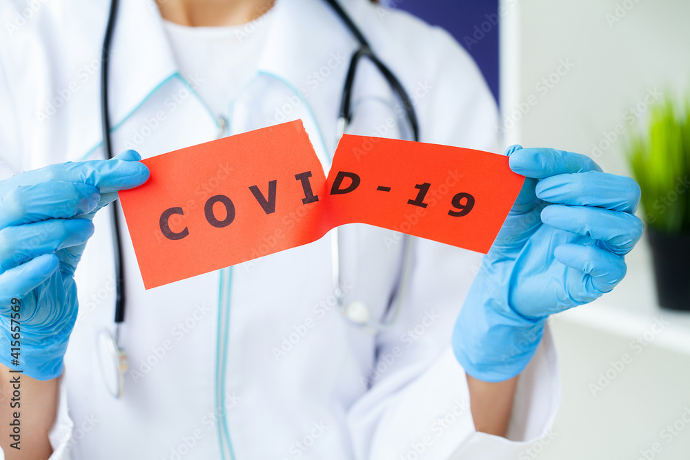 Doctor holding a paper card with text covid-19 Doctor holding a paper card with text covid-19