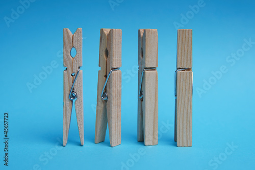 Wooden clothespin isolated on a blue background. The clothespin is a fastener used to dry clothes.