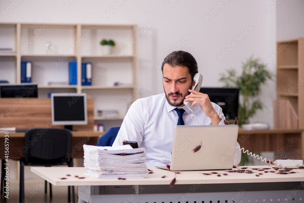 Young male employee and too many cockroaches in the office Young male employee and too many cockroaches in the office