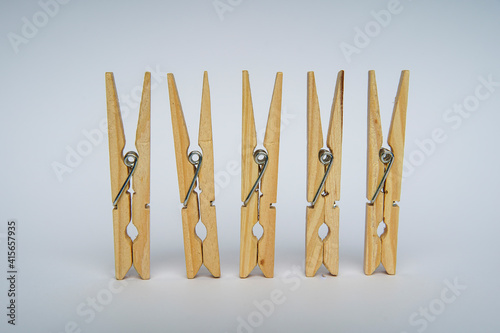 Wooden clothespin isolated on a withe background. The clothespin is a fastener used to dry clothes.