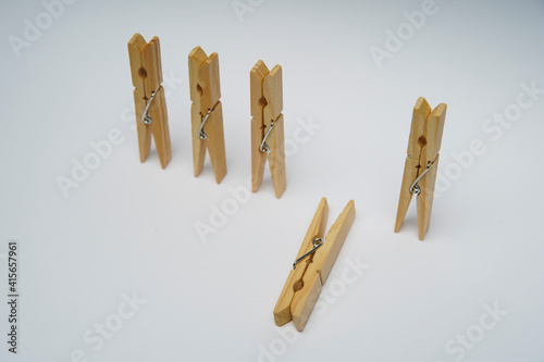 Wooden clothespin isolated on a withe background. The clothespin is a fastener used to dry clothes.