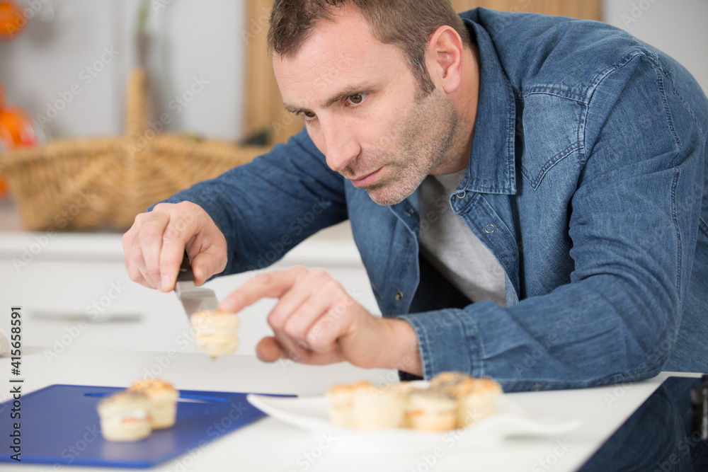 man transferring canapes on to a plate man transferring canapes on to a plate