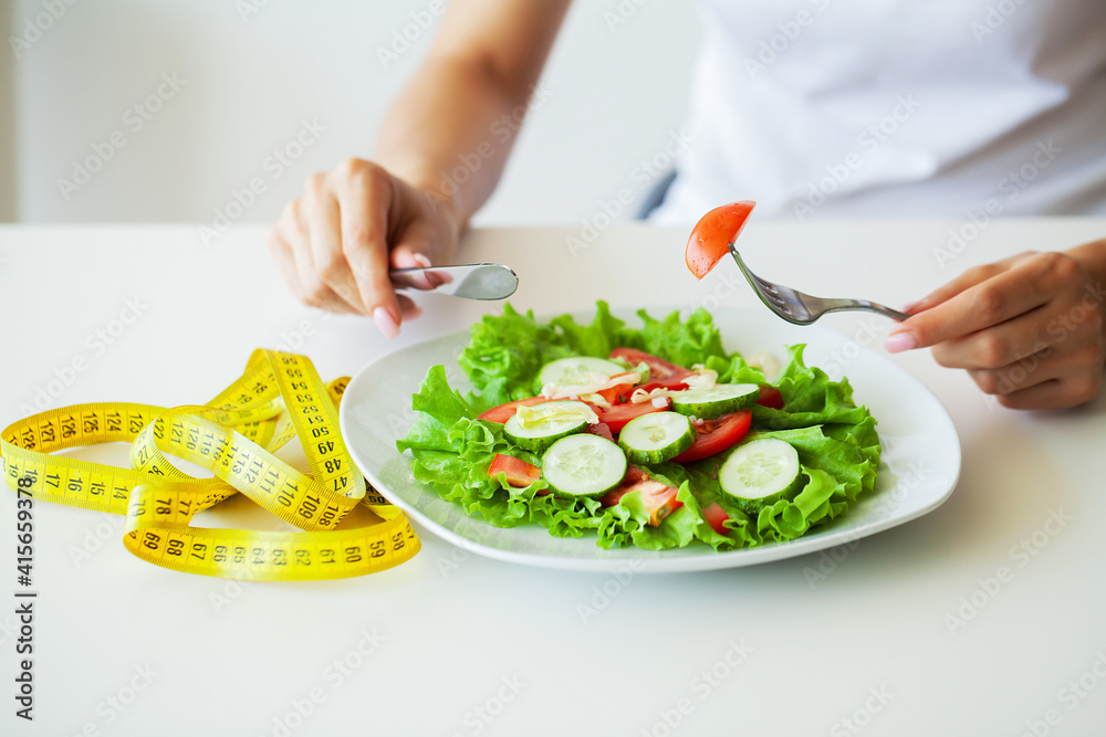 Closeup of fresh salad in a bowl and yellow measure tape