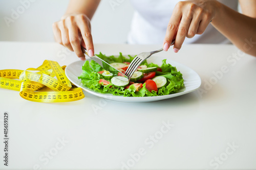 Closeup of fresh salad in a bowl and yellow measure tape