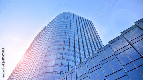 Downtown corporate business district architecture. Glass reflective office buildings against blue sky and sun light. Economy  finances  business activity concept. Rising sun on the horizon.