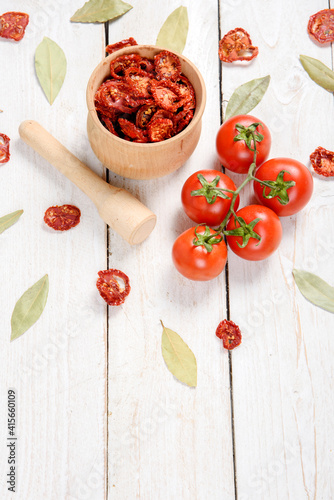 Closeup Dried cherry tomatoes from above on a wooden background, cut slices and whole tomatoes.