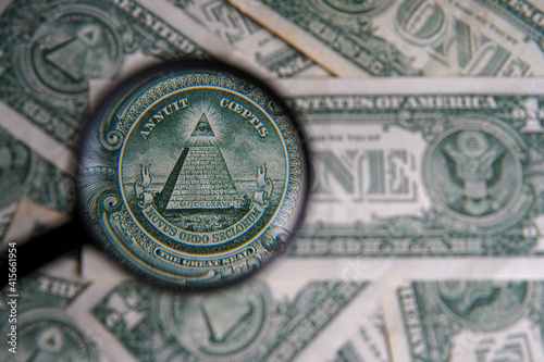 US dollar viewed through a magnifying glass, close up detail of the pyramid. Masonic symbols. Bricklayer signs on the dollar: All-seeing eye, pyramid. Bank image and commercial photo background.