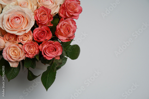 Beautiful white  red  tabby tea rose flowers in a vase  photographed from above on a white table. Spring flowers. Wedding mothers day and valentines day background. Selective small depth of field.