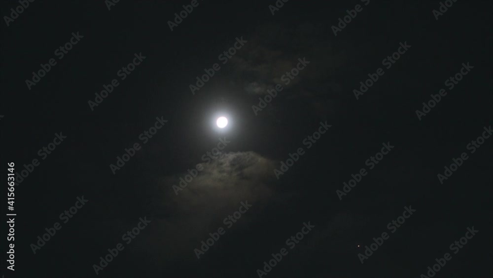 Time lapse of beautiful night sky. Full moon and clouds.