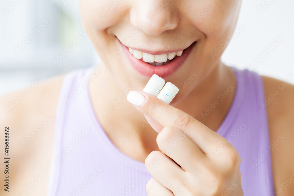 Beautiful young woman eating chewing gum, smiling Beautiful young woman eating chewing gum, smiling