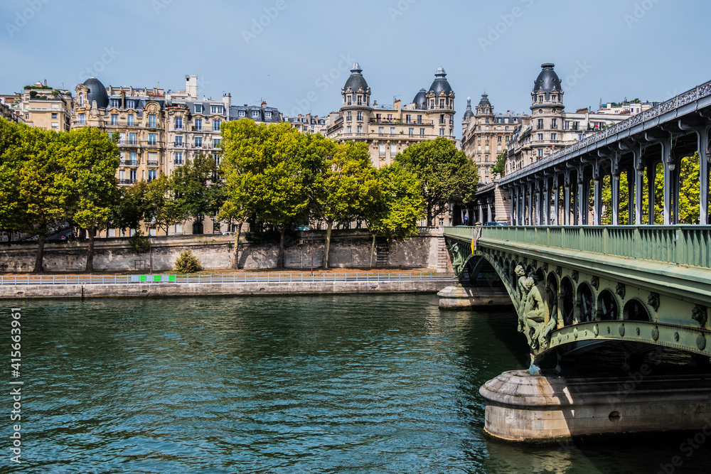 View of Pont de Bir-Hakeim (formerly pont de Passy) - a bridge that crosses the Seine River in Paris. Central arch decorated with monumental statues. France.