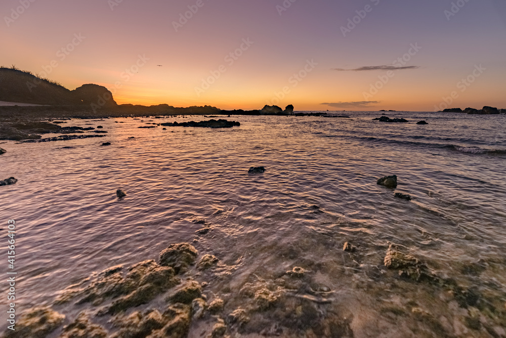 Sunset seen from a rocky beach