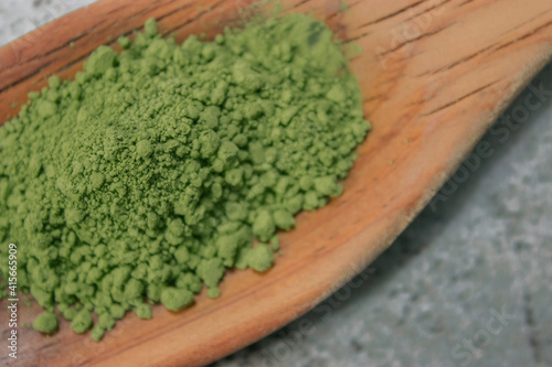 Close image of a detail of many matcha tea in powder on top of a wooden cooking stick. Matcha tea preparation 2021.