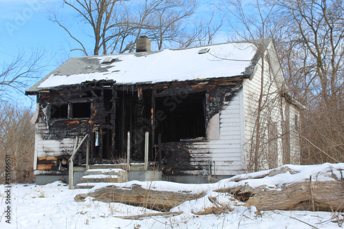 Abandoned and badly burned white cottage in Detroit's Brightmoor neighborhood in winter