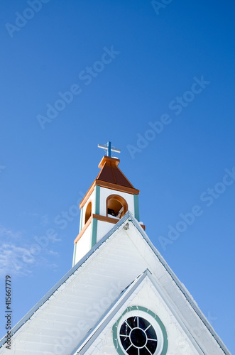 White and Brown Church Tower with Christian Cross on Blue Sky Background