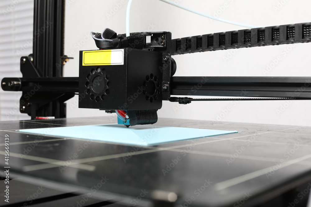3D printer printing PLA on a grid surface 3D printer printing PLA on a grid surface