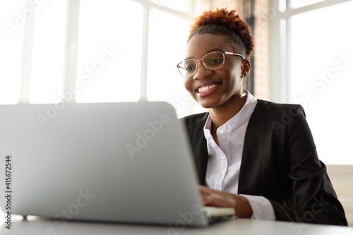 beautiful young african woman in glasses with laptop 