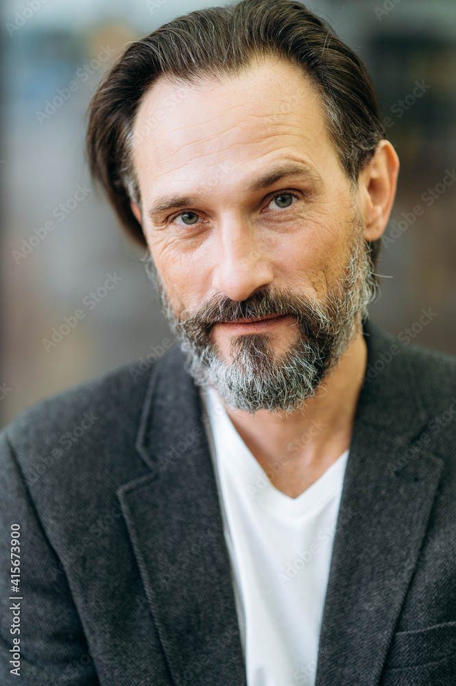 Close-up portrait of mature influential male in stylish suit. Serious grey-haired businessman looking directly at the camera, showing self confidence and success Close-up portrait of mature influential male in stylish suit. Serious grey-haired businessman looking directly at the camera, showing self confidence and success
