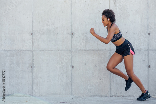 Afro athletic woman running outdoors. © Mego-studio