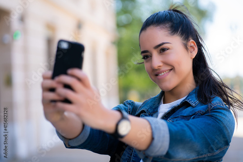 Young woman taking selfies with phone.