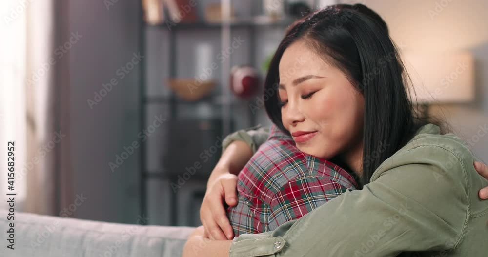 Close up of Asian happy lovely beloved couple young man and beautiful woman hugging together sitting on sofa at home. Wife and husband embracing feeling love. marriage relations concept Close up of Asian happy lovely beloved couple young man and beautiful woman hugging together sitting on sofa at home. Wife and husband embracing feeling love. marriage relations concept