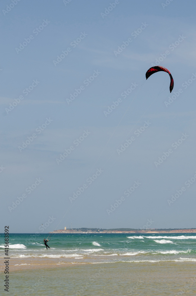 Young man practicing kitesurfing in the sea