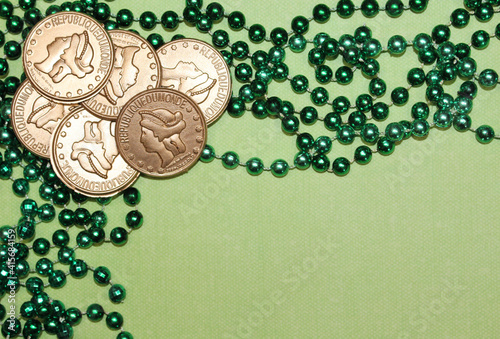 Cold Coins and Green Beads Isolated on Light Green Background with Copy Space for Saint Patrick's Day Banners Flat Lay for Advertisements, Cards, Sale Announcements St. Patty's Day  Pub Party Invite photo
