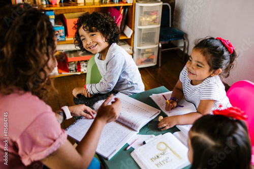 mexican children and mother at home in homeschooling concept in Mexico