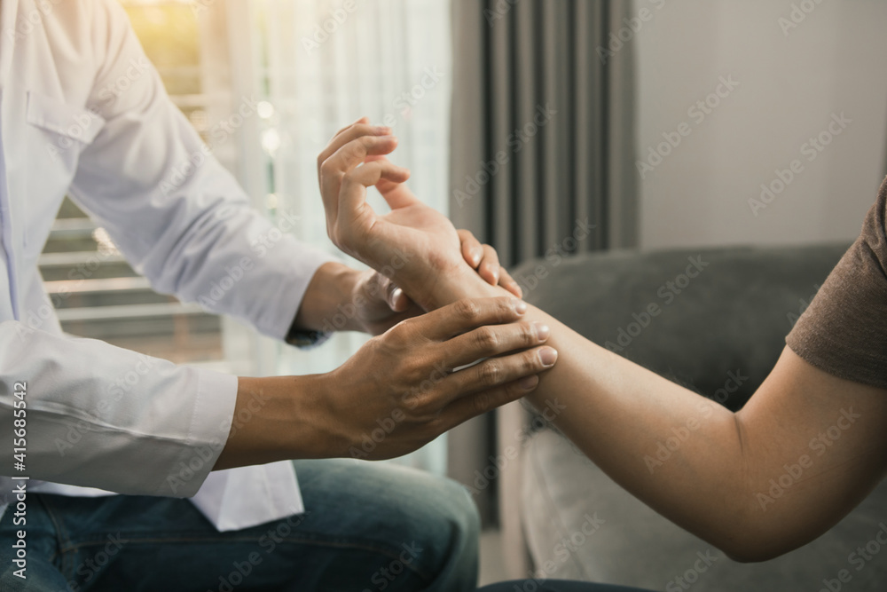 Physical therapist checks the patient wrist by pressing the wrist bone in clinic room.