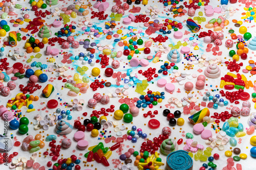 Confectionery and chocolate coated candies on the table. Variety of holiday sweets, lollipop, candy beans, marshmallows, colourful gummy, sugar dessert swirls, Liquorice on the table.