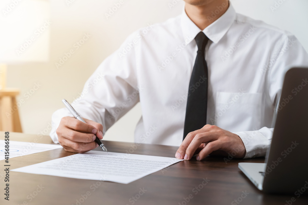 Businessman holds pen and signs agreement contract on the table. Businessman holds pen and signs agreement contract on the table.
